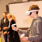 Junge mit VR-Brille und Controllern in der Hand