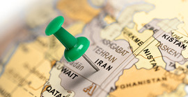 Ausschnitt eines Globus mit einer Pinnadel im Iran