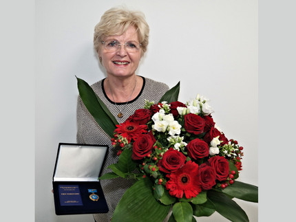 Dr. Doris Gebert mit Blumenstrauß und Medaille