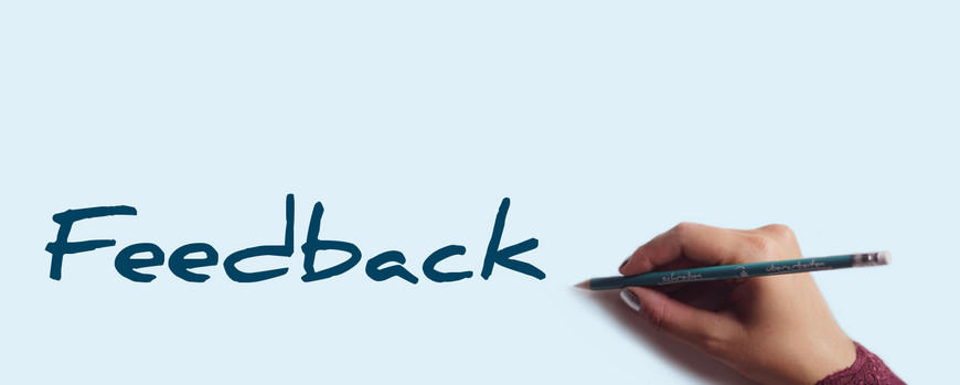 Image: “Feedback” logo, with a hand to the right holding a green Writing Assistance Program pen.