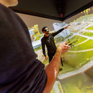 Das Bild zeigt zwei Personen, die im 3D-Labor auf eine an die Wand projizierte Landschaft schauen.