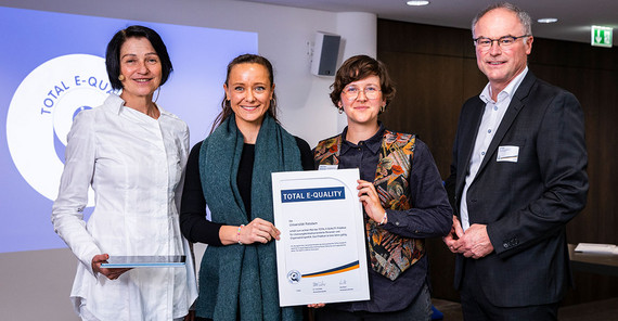 Die zentrale Gleichstellungsbeauftragte der Universität Potsdam, Christina Wolff, und ihre Referent*in, Franzi Fiene, bei der Verleihung des TOTAL E-QUALITY Prädikats.