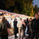 Mehrere Personen vor erleuchteten Marktständen