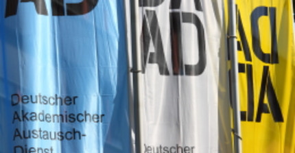 Drei Fahnen mit jeweils dem Logo des DAAD