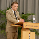 Präsident Prof. Oliver Günther, Ph.D. begrüßt die Absolvent*innen an einem Rednerpult auf der Bühne.