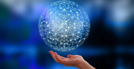 Eine Hand hält einen lediglich aus Bildpunkten bestehenden Globus