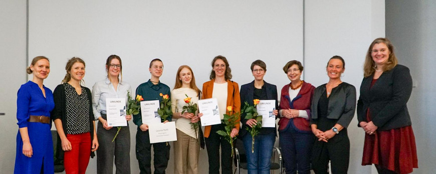 Gruppenbild Inklusionspreis 2025 Siegerinnen auf der Bühne Ein Gruppenbild von Menschen. Die Gewinner des Inklusionspreises mit einer orangenen Rose, den Urkunden und den Geschenken in der Hand.