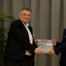 Prof. Florian Schweigert gratuliert Najibullah Kakar. Beide halten zusammen ein Buch über die Universität potsdam in die Kamera.