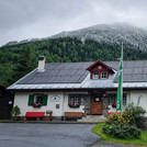 Summer scene with snow in front of a cosy hut in Zwieselstein