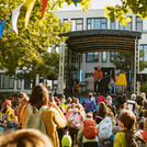 Mann auf einer Bühne, davor viele Kinder