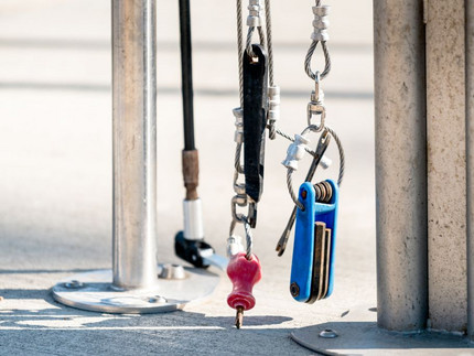 Bicycle tools hang next to two metal stands Bicycle tools hang next to two metal stands