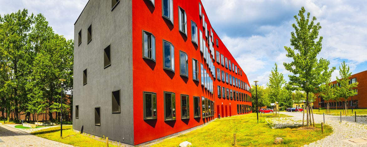 Ein rotes Gebäude, das eine wellenförmig geschwungene Fassade hat