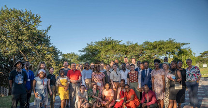 Gruppenbild von Studierenden der Universität Potsdam und der Africa University in Simbawe stehen gemeinsam unter blauem Himmel.