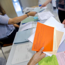 Hände reichen sich gegenseitig Stimmzettel