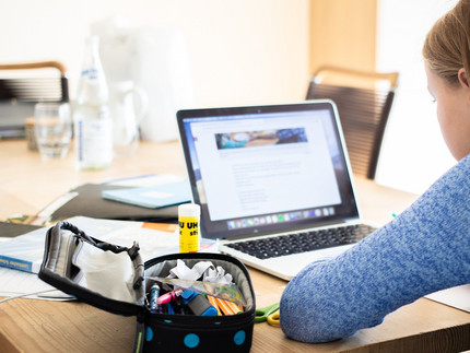 Ein Mädchen sitzt vor dem Laptop