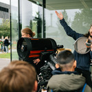 Mann steht neben einem Teleskop