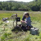 Photo of two people installing electronics & a solar panel for soil moisture sensors on a meadow | photo: Cosmic Sense Consortium