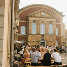 Ein Blick in den Innenhof von Haus 8 mit stimmungsvollem Abendlicht: Viele Menschen in vielen Gruppen tauschen sich aus.