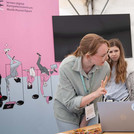 Eine Frau erklärt einem Kind etwas am Laptop