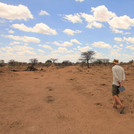 3 people walking on a very dry rangeland