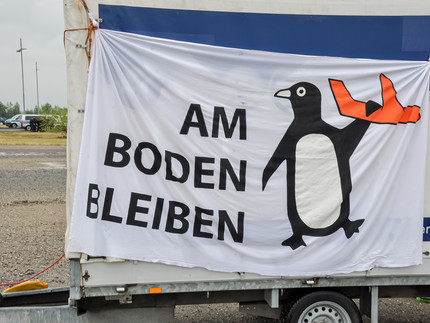 A banner with a big penguin holding a plane