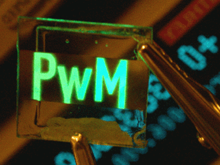 In einem durchsichtigen Kristall sind die Buchstaben "PwM" hologram-ähnlich abgebildet.