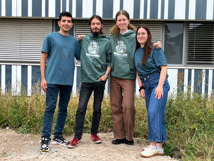 vier Personen vor einem Gebäude