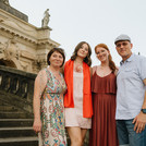 Vier Menschen posieren auf den Treppen von Haus 9 am Neuen Palais.