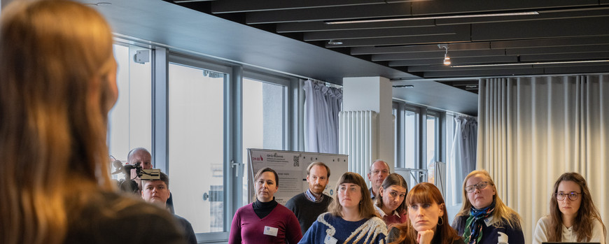 Eine Vielzahl an Menschen guckt einer Vortragenden Person zu