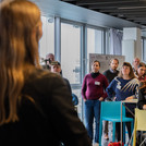 Eine Vielzahl an Menschen guckt einer Vortragenden Person zu