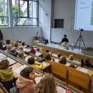 Hörsaal mit Kindern, vorn Referentin und ausgestopfter Biber