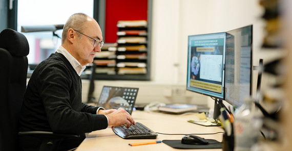 Forscher sitzt an seinem Arbeitsplatz vor dem PC