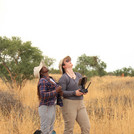 NamTip researchers looking up in the sky at a drone flying over a dry savanna rangeland
