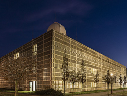 Dreistöckiges goldenes Gebäude mit Übungsobservatorium bei Nacht