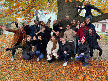 Mehrere Personen stehen vor einem Baum