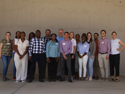 Group picture of NamTip researchers in front of neutral background