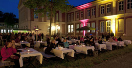 Veranstaltung der Universitätsgesellschaft auf dem Campus Am Neuen Palais: Gäste sitzen an Tischen auf dem Innenhof der Mensa.