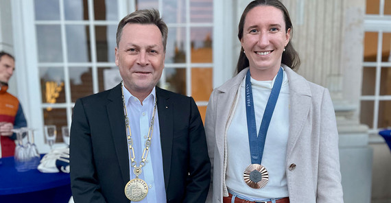 Zweimal Edelmetall: Olympia-Medaillengewinnerin im Rudern Maren Völz und Uni-Präsident Prof. Oliver Günther mit Amtskette.