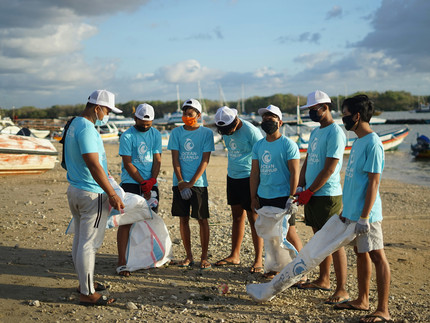 Gruppe von freiwilligen helfern am Strand.