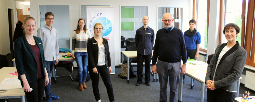 Gruppen von Menschen im Raum vor Roll-Up