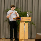 Bryan Nowack am Rednerpult auf der Bühne.