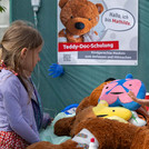 Ein Kind neben einem großen Teddy