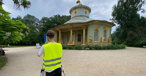 Student bei der Vermessung des Teehauses mit einem terrestrischen 3D-Laserscanner.