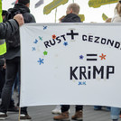 Protesters carrying a banner with the phrase 'peace' plus 'health' equals 'shrink'