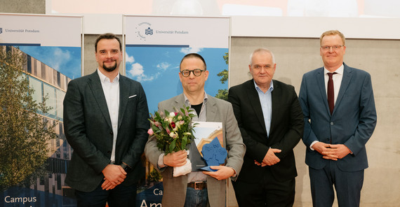 Prof. Taubert steht, mit einem Preis in der Hand, zusammen mit Sascha Thormann bei einer preisverleihung