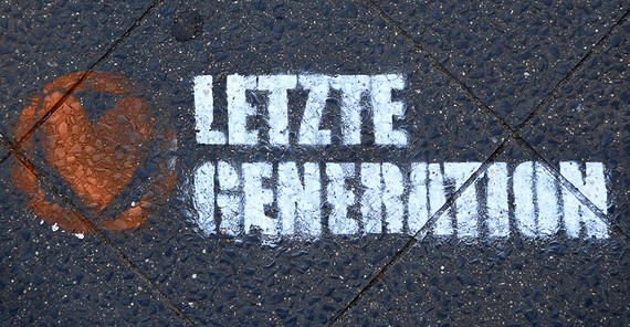 Foto von oben auf einen Schriftzug "Letzte Generation", der auf ein Straßenpflaster gesprüht ist