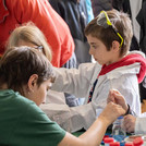 Zwei Kinder mit Kitteln und Schutzbrillen führen ein Experiment durch